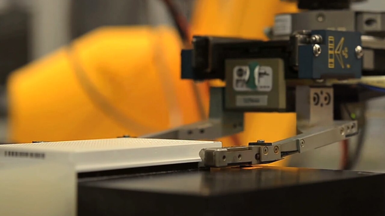 Robot arm handles an assay plate
