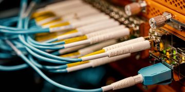 From above of optical switch equipment with many similar connectors with rubber cables and metal parts