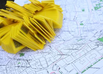 Stack of yellow QR code markers placed on a detailed map for location tracking and navigation.