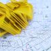Stack of yellow QR code markers placed on a detailed map for location tracking and navigation.