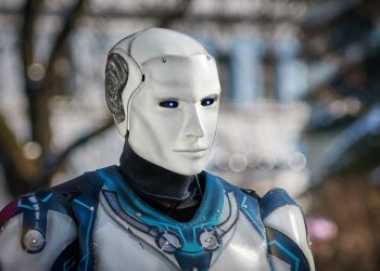 Close-up of a futuristic humanoid robot with metallic armor and blue LED eyes.