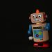 A vibrant wooden toy robot stands on a dark surface, showcasing vivid colors and playful design.