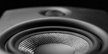 A detailed black-and-white close-up image of a speaker, highlighting its intricate design.