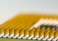 Detailed macro shot of a CPU microchip with focus on golden pins, highlighting technology details.
