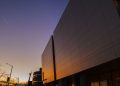 Stunning modern building exterior reflecting sunset light, urban skyline view.