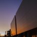 Stunning modern building exterior reflecting sunset light, urban skyline view.