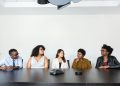 A diverse group of professionals having a meeting in a modern office setting. Teamwork and collaboration.