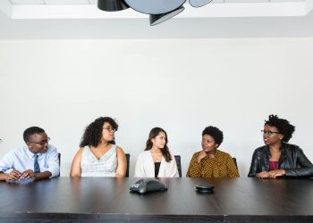 A diverse group of professionals having a meeting in a modern office setting. Teamwork and collaboration.