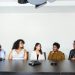 A diverse group of professionals having a meeting in a modern office setting. Teamwork and collaboration.