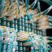 From below of fiber optic switch with sockets and connected rubber cables on blurred background