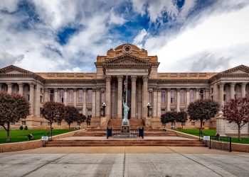 Front view of a neoclassical courthouse building in Colorado with lush greenery.
