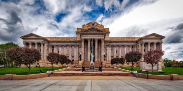 Front view of a neoclassical courthouse building in Colorado with lush greenery.
