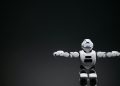 Studio shot of a humanoid robot with glowing eyes against a dark background, offering ample copyspace.