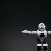 Studio shot of a humanoid robot with glowing eyes against a dark background, offering ample copyspace.