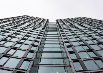 Low angle view of a modern office building with glass facade in Warsaw, Poland.