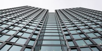 Low angle view of a modern office building with glass facade in Warsaw, Poland.