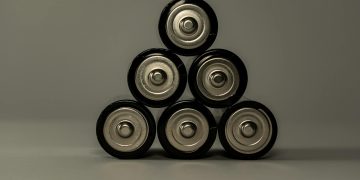Metallic AA batteries stacked in a pyramid shape, symbolizing power and energy storage.