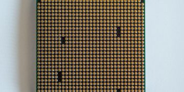 Detailed view of a computer processor, showcasing its pins, against a clean white backdrop.