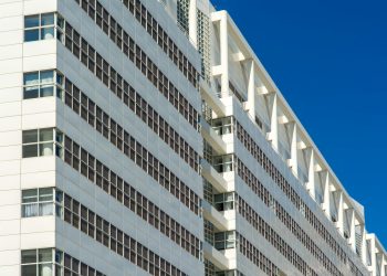 A striking white architectural structure in The Hague, Netherlands against a clear blue sky.