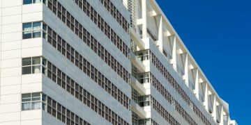 A striking white architectural structure in The Hague, Netherlands against a clear blue sky.