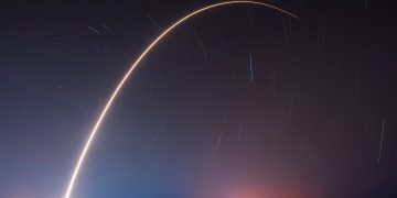 A breathtaking shot of a rocket launch, creating a vivid trail under a starry night sky.