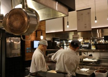 Two chefs working in a professional kitchen, highlighting culinary expertise and teamwork.
