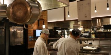 Two chefs working in a professional kitchen, highlighting culinary expertise and teamwork.
