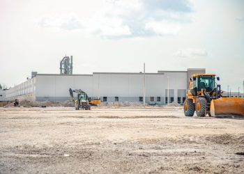 A large construction site featuring heavy machinery and industrial building in progress.