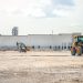A large construction site featuring heavy machinery and industrial building in progress.