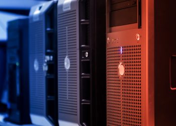 Close-up of tower servers in a data center with blue and red lighting.
