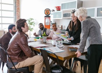 Colleagues engaged in a collaborative business meeting around a table in a modern office setting.