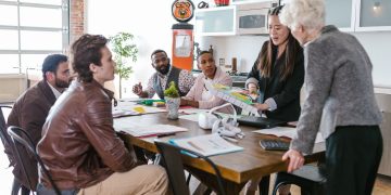Colleagues engaged in a collaborative business meeting around a table in a modern office setting.