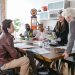 Colleagues engaged in a collaborative business meeting around a table in a modern office setting.