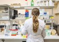 A female scientist conducting research in a well-equipped laboratory, focusing on chemical analysis.
