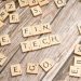 Fintech spelled out with wooden letter tiles on a rustic wooden background.