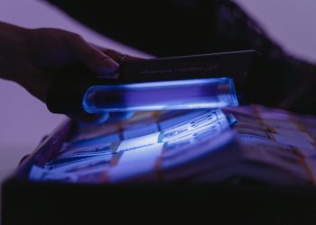 A close-up shot of banknotes under UV light to verify currency authenticity and detect counterfeits.