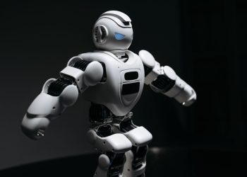 Close-up of a futuristic humanoid robot under dramatic lighting in dark ambiance.