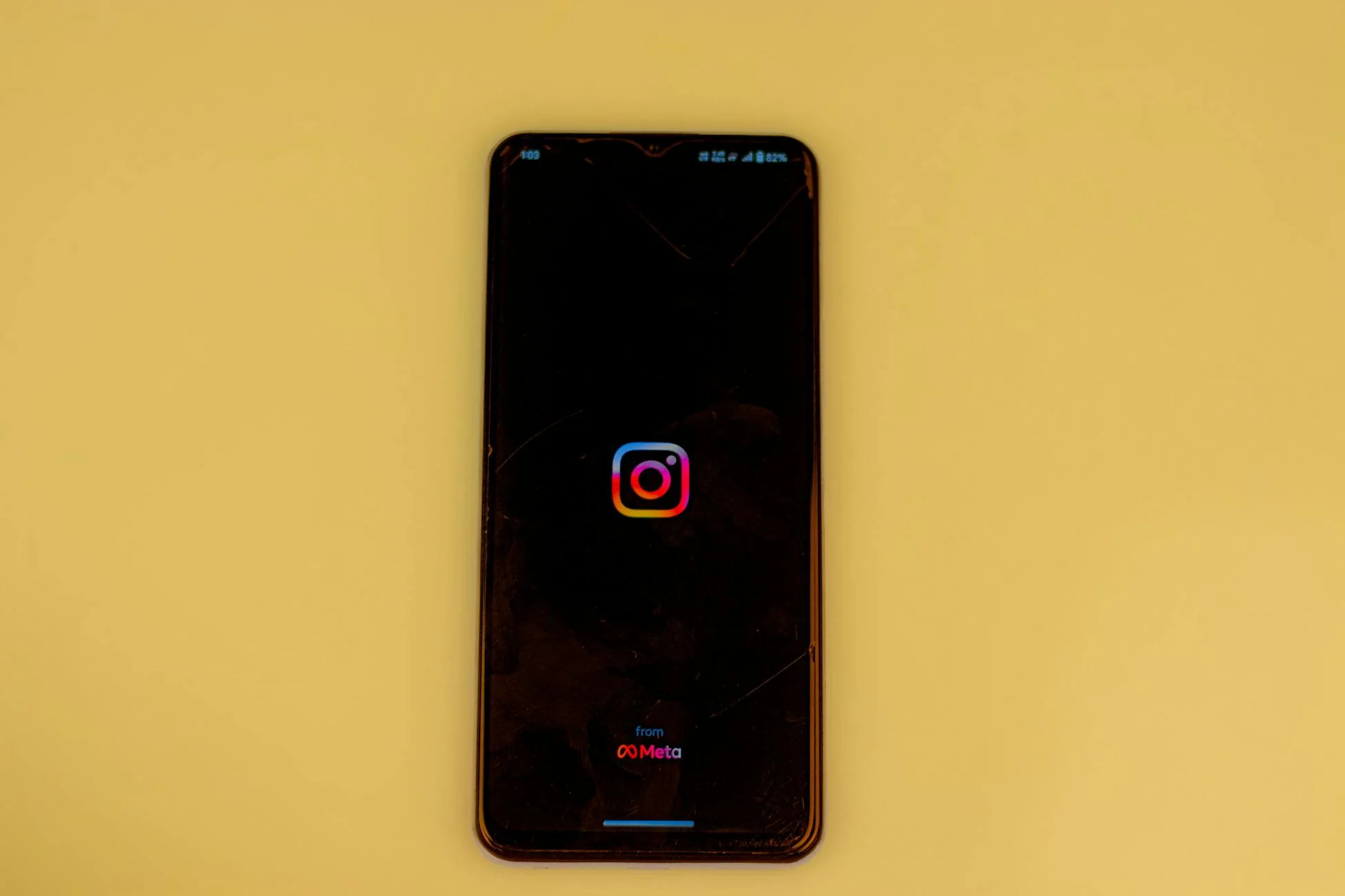 A smartphone displays the Instagram logo on a vibrant yellow background, emphasizing modern social media themes.