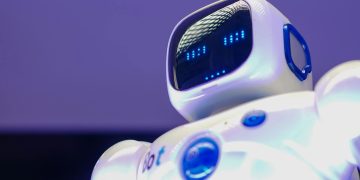 A modern humanoid robot with digital face and luminescent screen, symbolizing innovation in technology.