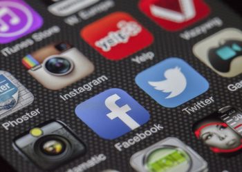 Close-up image of various social media app icons on a smartphone screen.