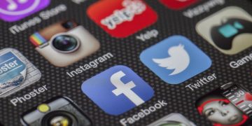 Close-up image of various social media app icons on a smartphone screen.