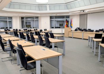 Spacious and modern meeting room in Niedersachsen, Germany, with desks and flags.