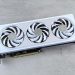 Stylish white graphics card with three cooling fans on a neutral background, ideal for tech enthusiasts.
