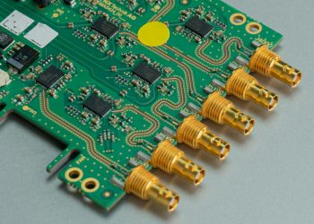 Detailed view of a green circuit board featuring multiple connectors and intricate components.