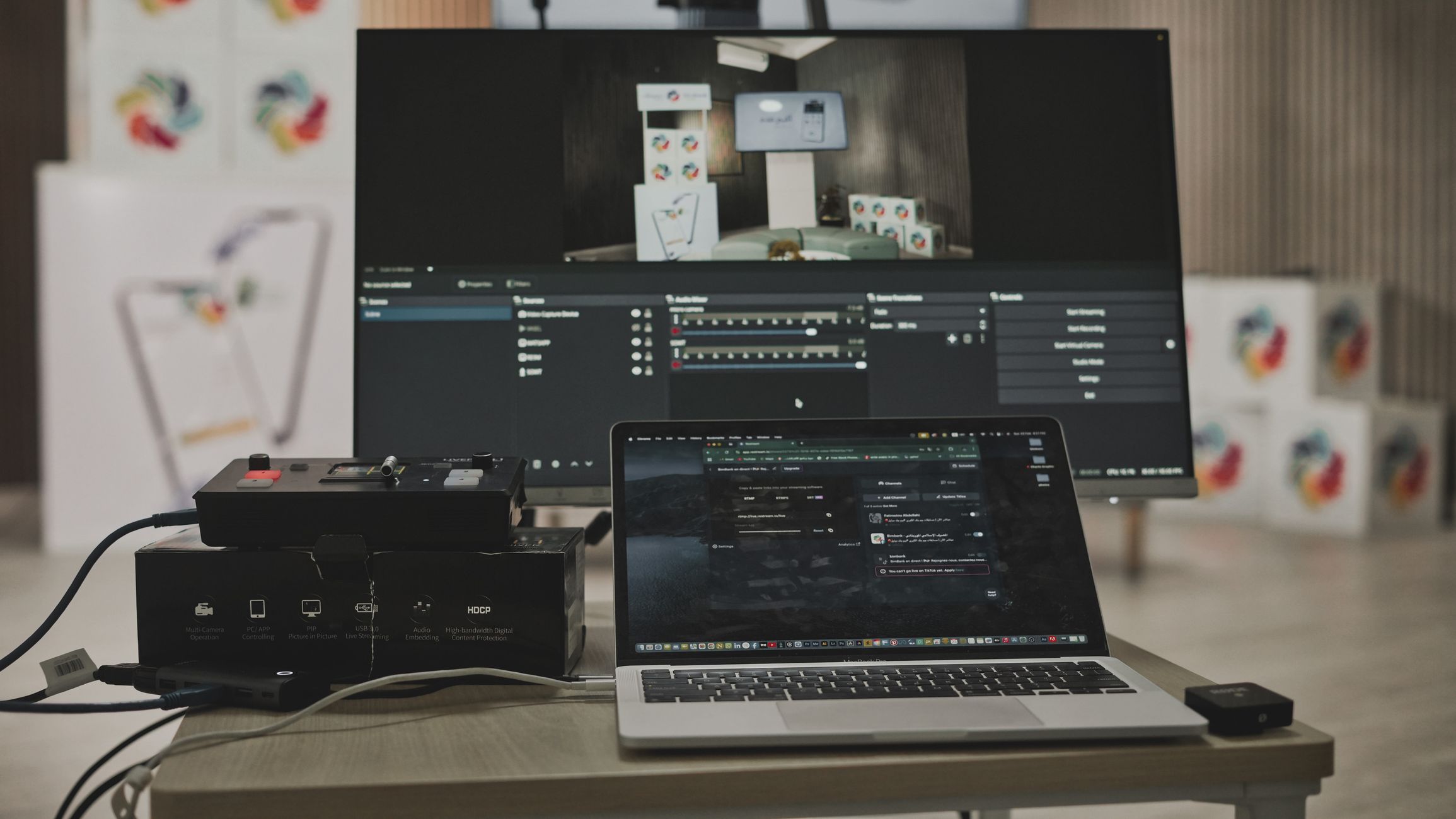 Multimedia setup featuring a laptop and a large monitor in a tech-savvy workspace.