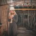 Young female engineer with hard hat checking phone at construction site.
