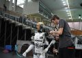 Technician working on humanoid robot at a tech exhibition in Guimaraes, Portugal.
