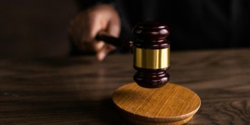 A gavel striking a sound block, symbolizing justice and legal authority in a courtroom setting.