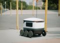 Futuristic autonomous delivery robot navigating a city street, showcasing modern technology.