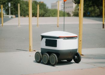 Futuristic autonomous delivery robot navigating a city street, showcasing modern technology.